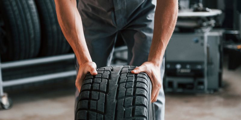 Ein Mann rollt einen Reifen