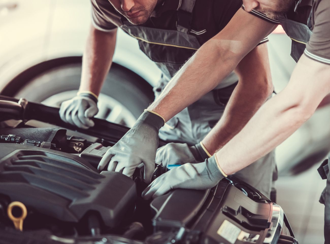 Zwei Männer schauen sich den Motor eines Autos an
